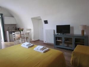 a living room with a bed and a tv at Arco Michele in Putignano