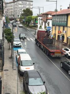 a truck driving down a city street with cars at Casa Vilela in Arzúa