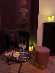 a tray of food and wine glasses on a table at La Muse Ment - Suite La Valtesse de la Bigne in Liège