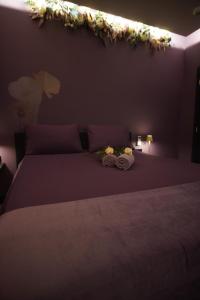 a bedroom with a bed with flowers on the wall at La Muse Ment - Suite La Valtesse de la Bigne in Liège