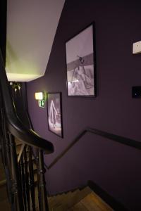 a purple room with a staircase with pictures on the wall at La Muse Ment - Suite La Valtesse de la Bigne in Liège