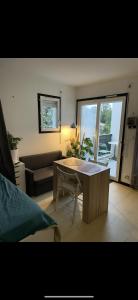 a living room with a table and a couch at Studio cosy proche bordeaux avec balcon in Villenave-dʼOrnon