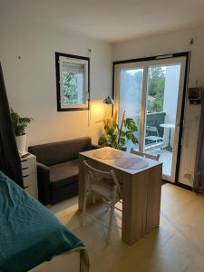 a living room with a table and a couch at Studio cosy proche bordeaux avec balcon in Villenave-dʼOrnon