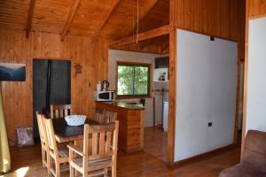 a kitchen and dining room with a table and chairs at Los Quenes River Lodge in Los Queñes