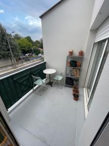 a balcony with two chairs and a table on a building at Studio cosy proche bordeaux avec balcon in Villenave-dʼOrnon +3 photos