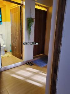 a bathroom with a door open to a room with a toilet at Star Villas Nyahururu in Nyahururu