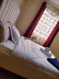 a bed in a room with a window with a bedvisor at Star Villas Nyahururu in Nyahururu