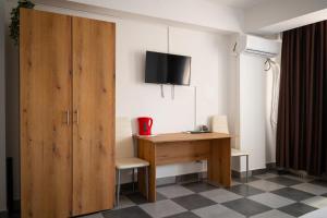 a room with a desk and a tv on a wall at Occidental Wise Transit in Bucharest +65 photos