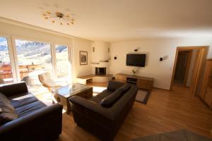 a living room with a couch and a television at Residenz Ambassador A22 in Leukerbad
