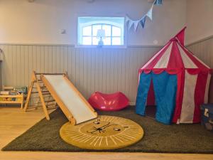 a room with a play room with a tent and a slide at Kvarnviks Gård Close to Sea & Charming Country Stay in Klagstorp