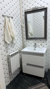 a bathroom with a sink and a mirror and towels at Central Square Apartment in Ternopil