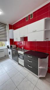 a red and white kitchen with a stove top oven at Central Square Apartment in Ternopil