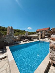 a swimming pool in a villa with a stone wall at Stara Kruska in Podgorica