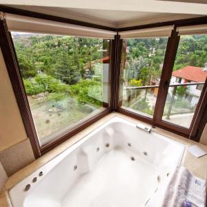 a bath tub in a room with windows at Suites de la Colina in La Cumbrecita +65 photos