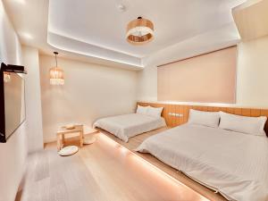 a small room with two beds and a table at 初見庭野 in Ch'ing-shui