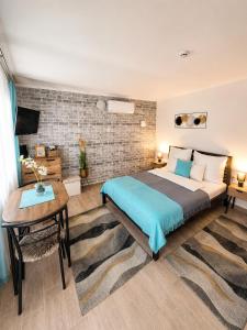 a bedroom with a bed and a table and a desk at Várfal apartman I in Eger