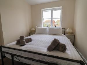 a bedroom with a large white bed with towels on it at 31 Llys Ogwen in Prestatyn