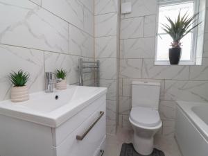 a white bathroom with a toilet and a sink at 31 Llys Ogwen in Prestatyn +20 photos