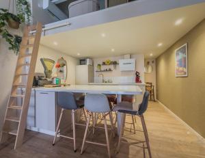 a room with a kitchen and a loft bed at L'échappée in Collobrières