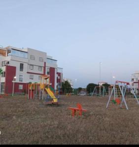 a playground with slides and play equipment in a field at Appartement à côté de la plage in Tangier