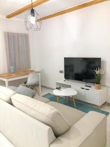 a living room with a white couch and a tv at Rooms in Palma Center in Palma de Mallorca
