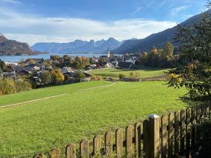 a field of green grass next to a fence at Garten Apartment Diwoky in Sankt Gilgen