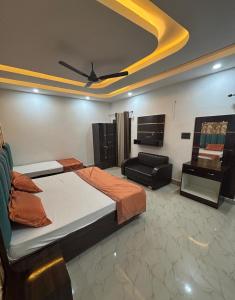 a bedroom with a bed and a couch and a ceiling at Hotel Shree Ji in Tālbahat