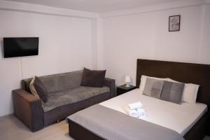 a hotel room with a bed and a couch at Occidental Wise Transit in Bucharest