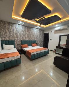 a room with two beds and a couch in it at Hotel Shree Ji in Tālbahat