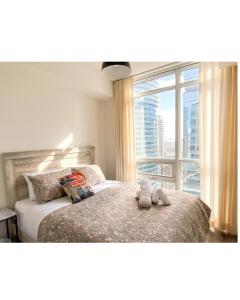 a bedroom with a bed and a large window at Prime Location - Stunning 2-bdrm Condo in Toronto