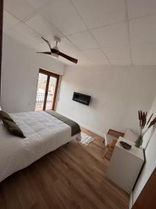 a white bedroom with a bed and a window at Raíces del Noroeste in Caravaca de la Cruz +6 photos