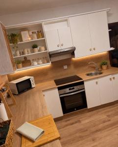 a kitchen with white cabinets and a sink at Raíces del Noroeste in Caravaca de la Cruz