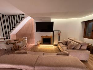 a living room with a couch and a tv on the wall at Raíces del Noroeste in Caravaca de la Cruz