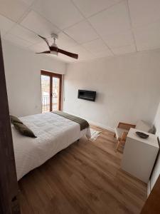 a white bedroom with a bed and a window at Raíces del Noroeste in Caravaca de la Cruz