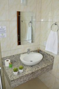 um banheiro com uma pia e um espelho em Pousada Recanto dos Feijós em Florianópolis