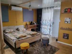 a bedroom with a bed and a yellow wall at Loc 'FCathy in Saint-Benoît