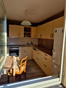 a kitchen with wooden cabinets and a table with a chair at Elbsandstein vor der Tür in Lohmen