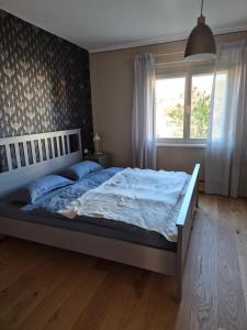a bedroom with a large bed with a window at Elbsandstein vor der Tür in Lohmen
