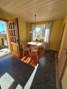 a dining room with a table and chairs and windows at Elbsandstein vor der Tür in Lohmen +4 photos
