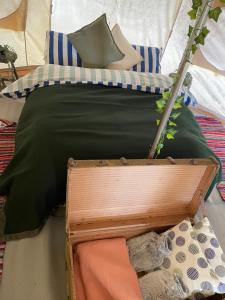 a bed with green sheets and pillows in a tent at The Spinney, close to Silverstone in Brackley