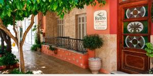 a building with a balcony and a door with a tree at Retro Rooms in Loutra Edipsou