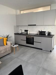 a kitchen with white cabinets and a couch in a room at Olympia's Guest House in Volos