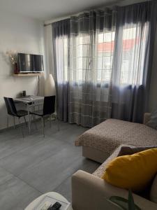 a living room with a couch and a table and a window at Olympia's Guest House in Volos