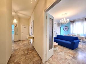 a living room with a blue couch and a dining room at Appartamento Miramare in Follonica