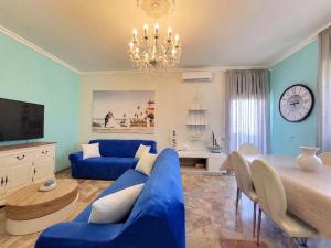 a living room with a blue couch and a clock at Appartamento Miramare in Follonica