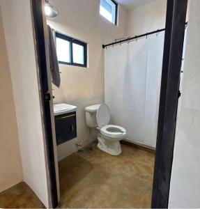 a bathroom with a toilet and a sink and a window at Coyote Room in Arteaga