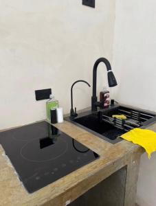 a kitchen with a sink and a black counter top at Coyote Room in Arteaga