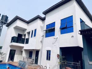 a white building with a swimming pool in front of it at Wesmont Hotels in Ikorodu