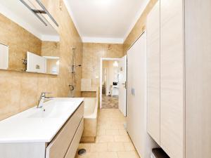 a bathroom with a white sink and a tub at Appartamento Miramare in Follonica +20 photos