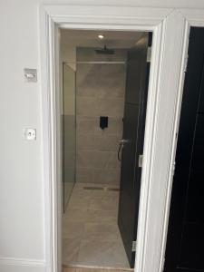 a glass door leading to a shower in a bathroom at Deluxe family room in Chessington +9 photos